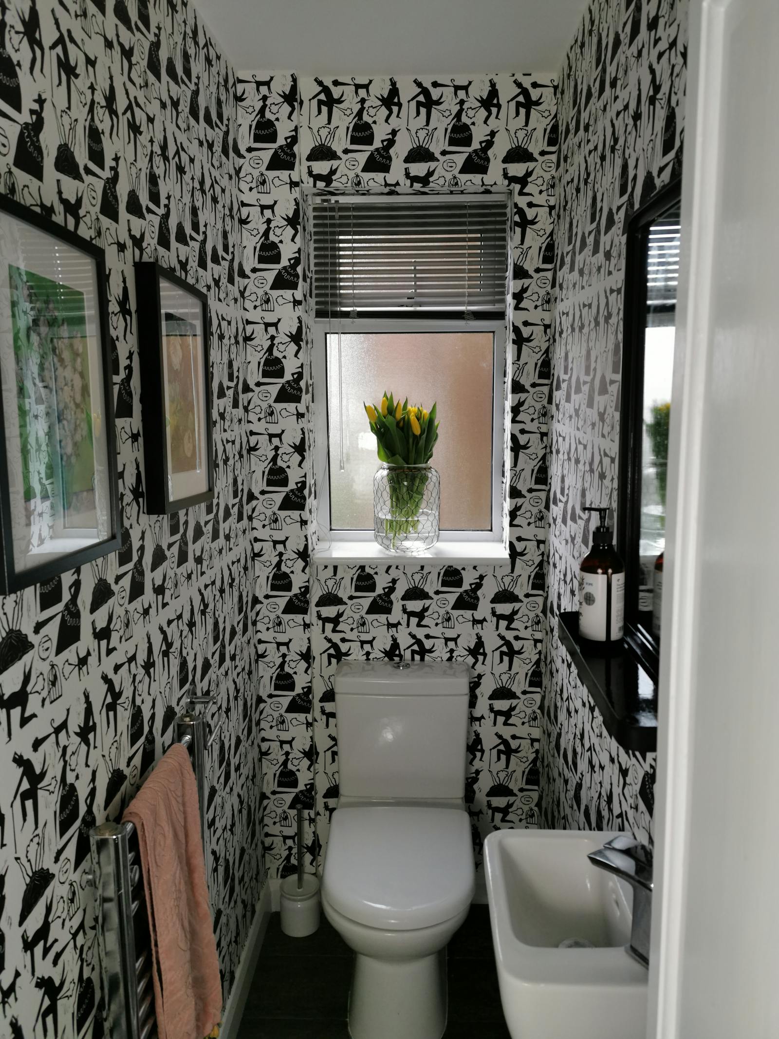 toilet room with patterned wallpaper in black and white