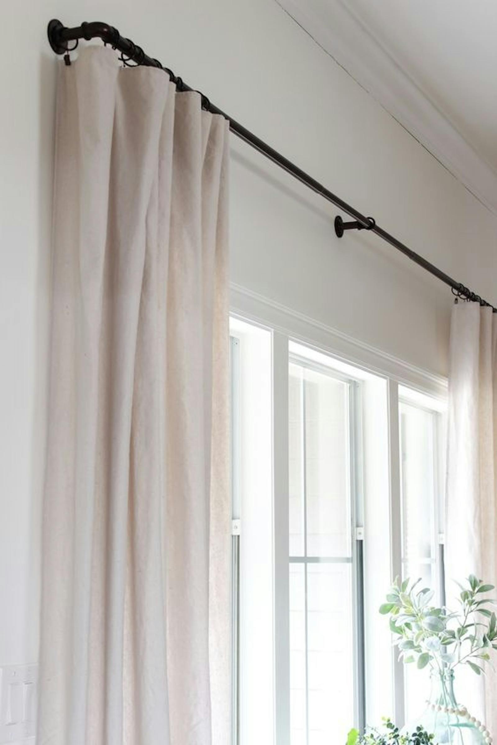 Black curtain rail with white linen curtains