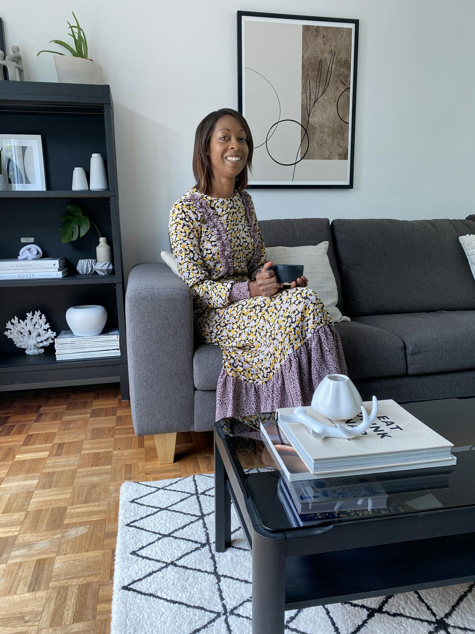 A woman sitting on a grey sofa