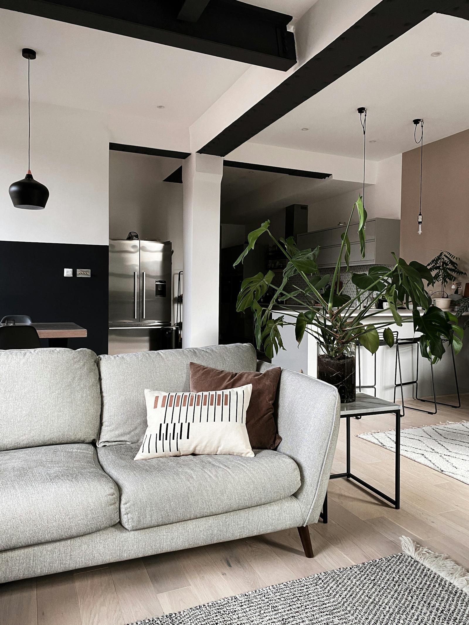 Living room with a grey sofa and kitchen in the background