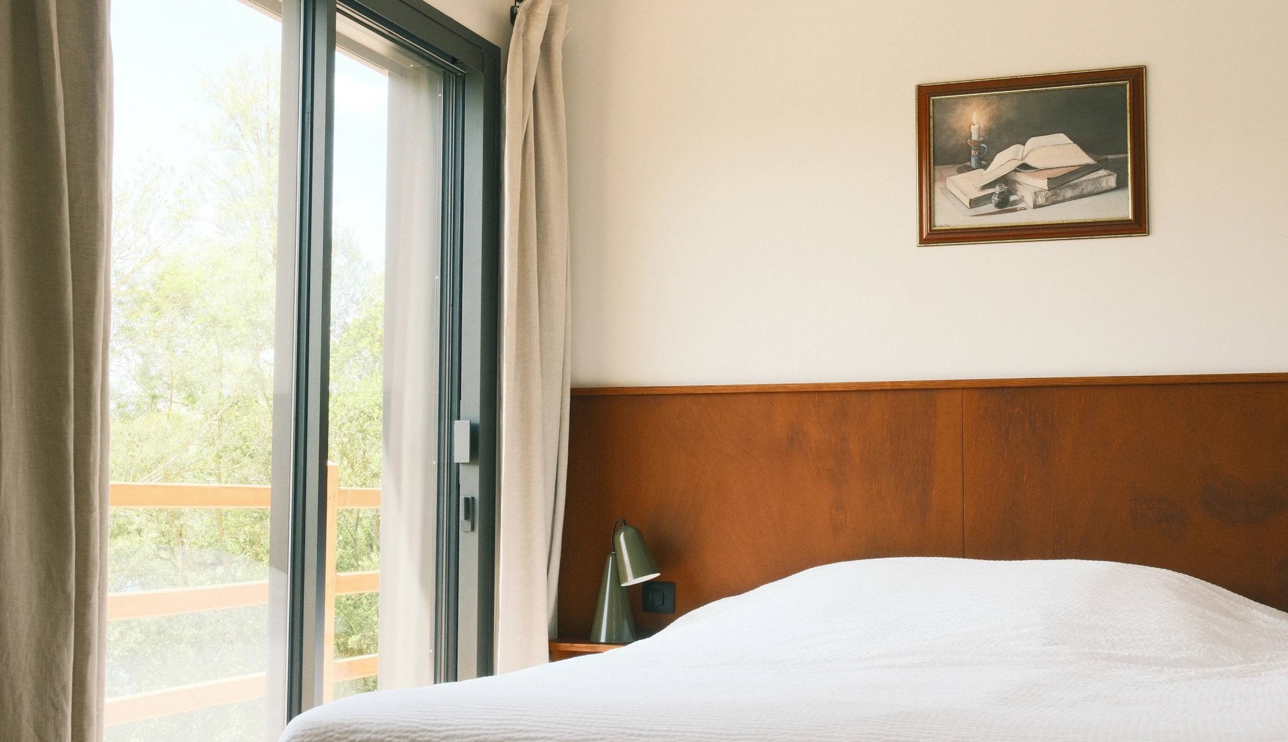 Bedroom with balcony, wooden headboard, natural light