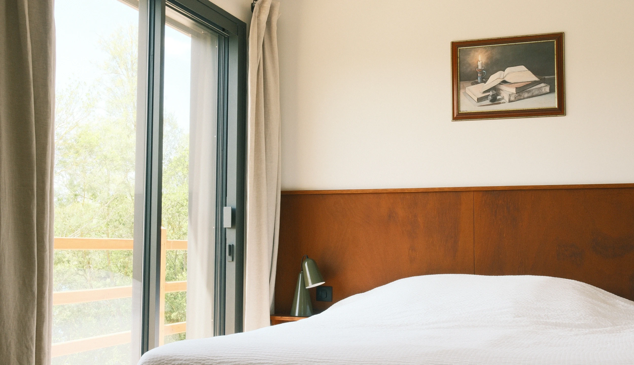 Bedroom with balcony, wooden headboard, natural light