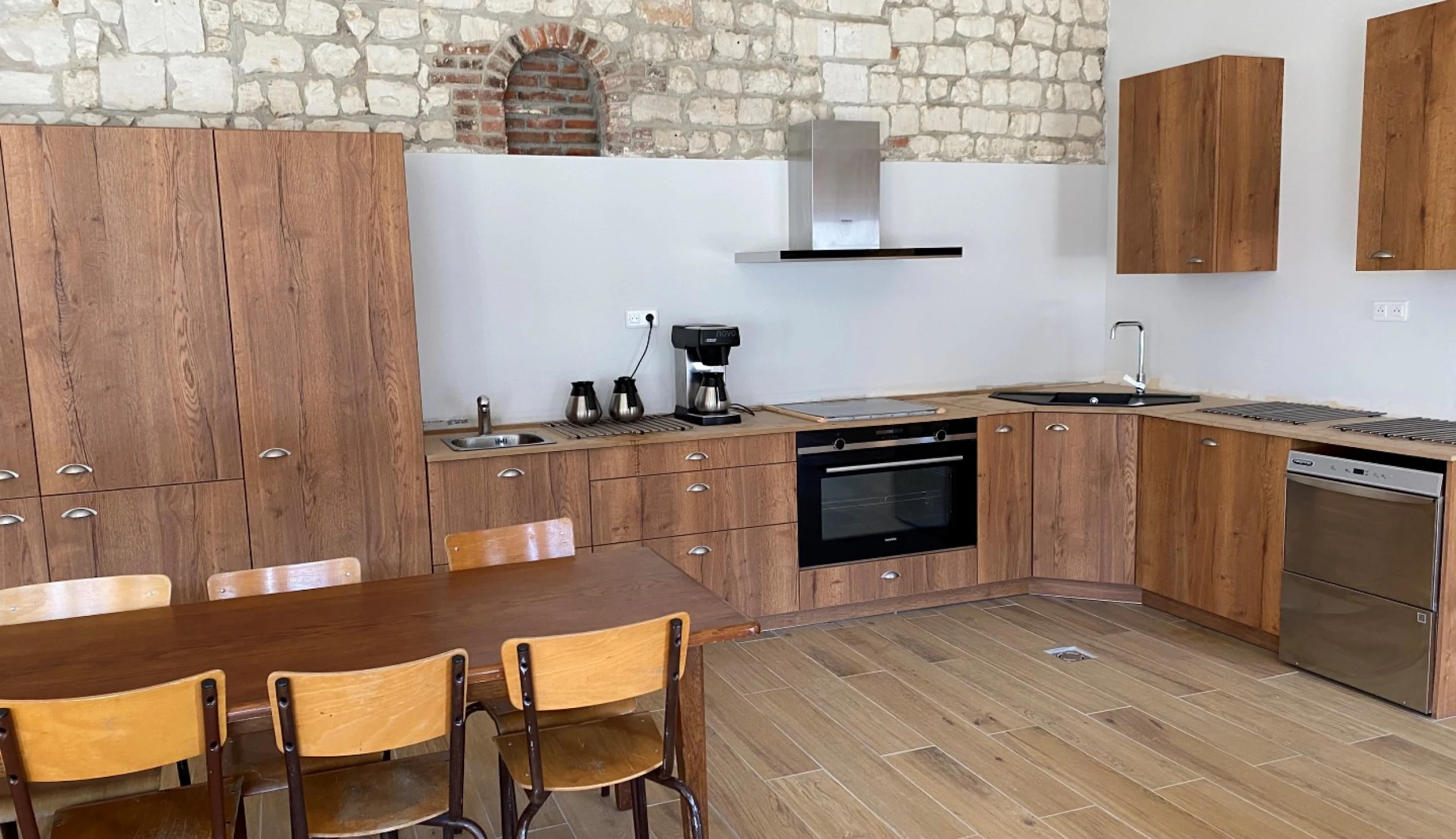 Wooden kitchen with filter coffee machine and stone wall