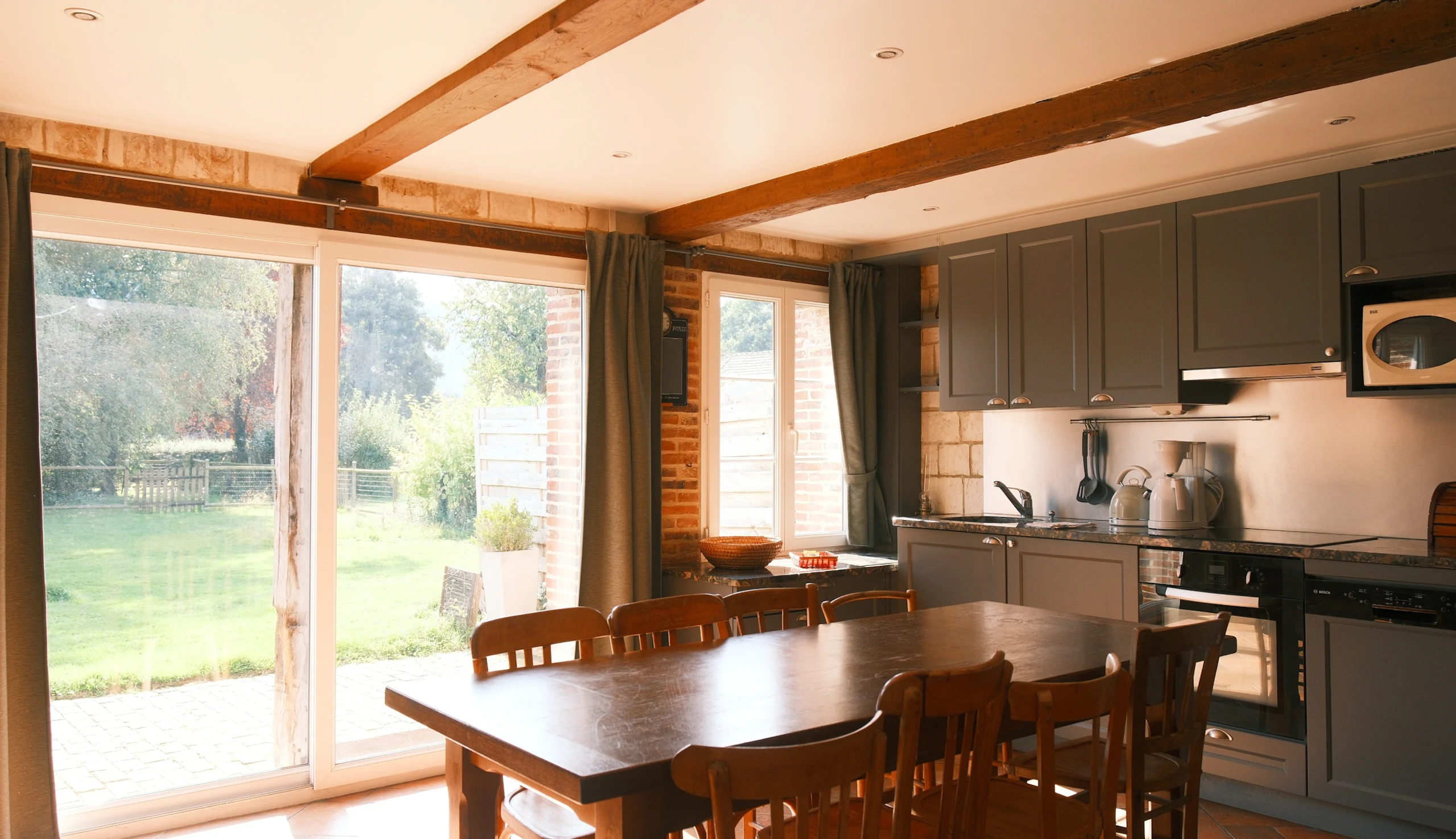 Fully equipped kitchen, wooden table, large bay window overlooking the garden