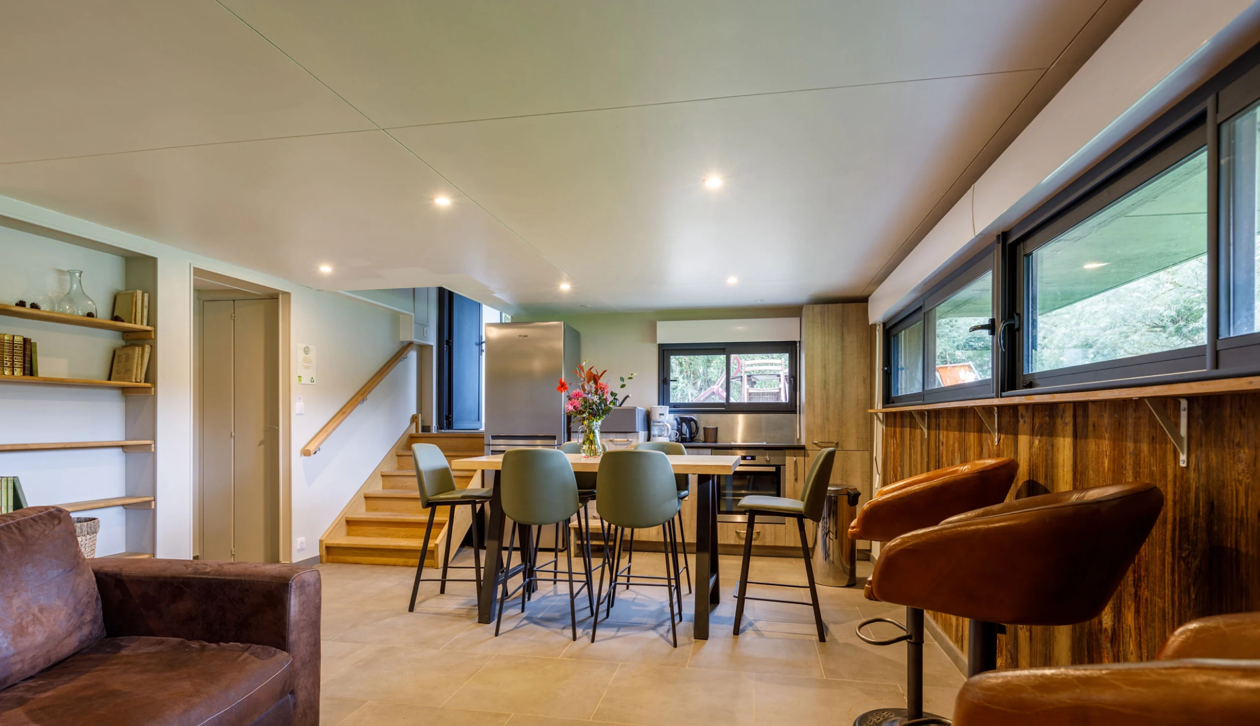 Living room with dining table, armchairs, and sofa