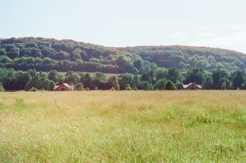 Champ d'herbe qui donne sur les Cabanes sur l'eau avec vue de la colline en fond