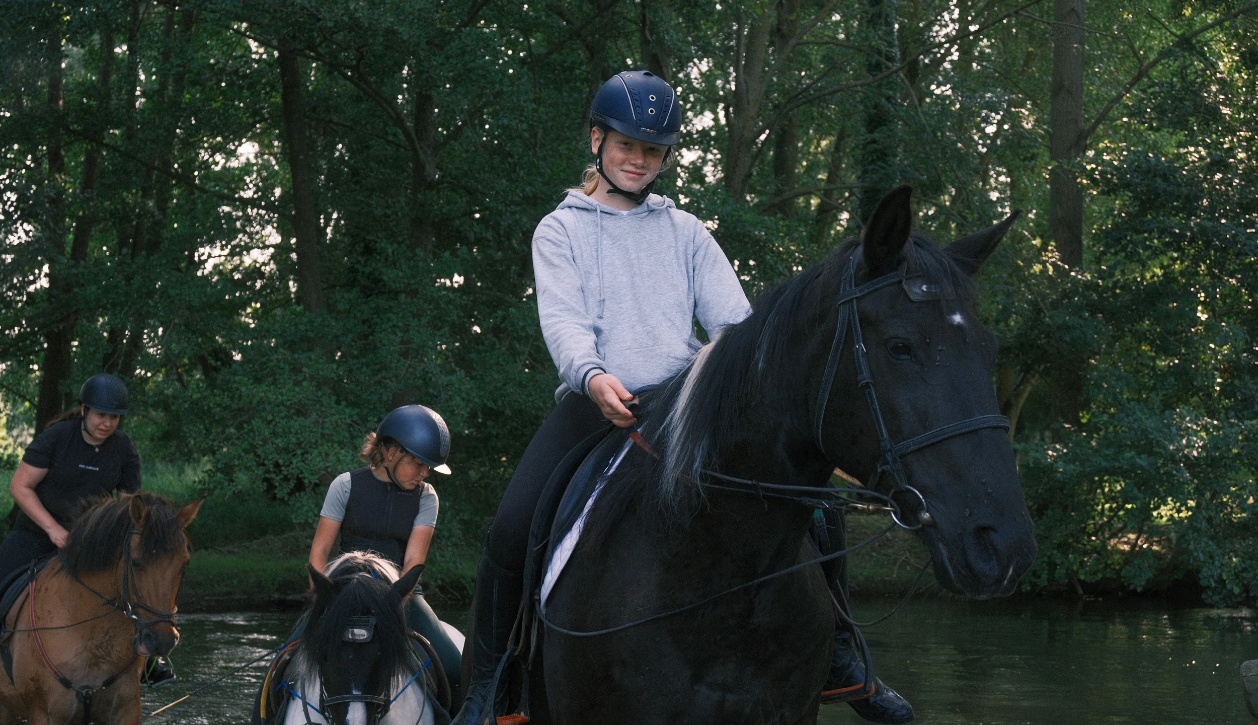 Rider crossing a river on a black horse