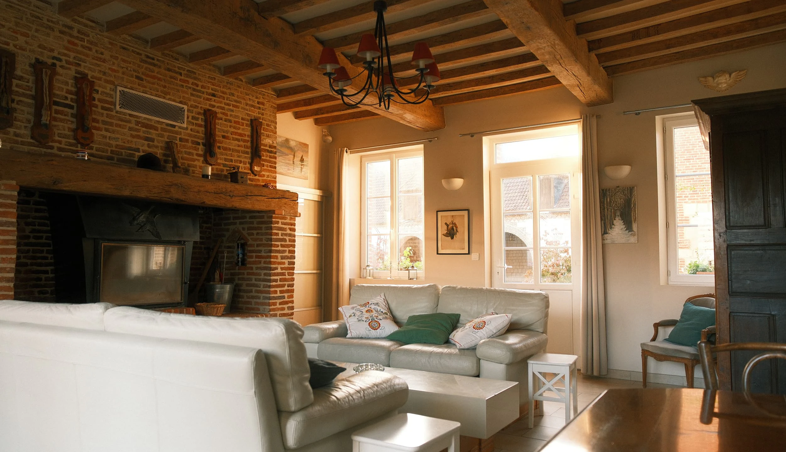 Large living room with central brick fireplace and two facing leather sofas