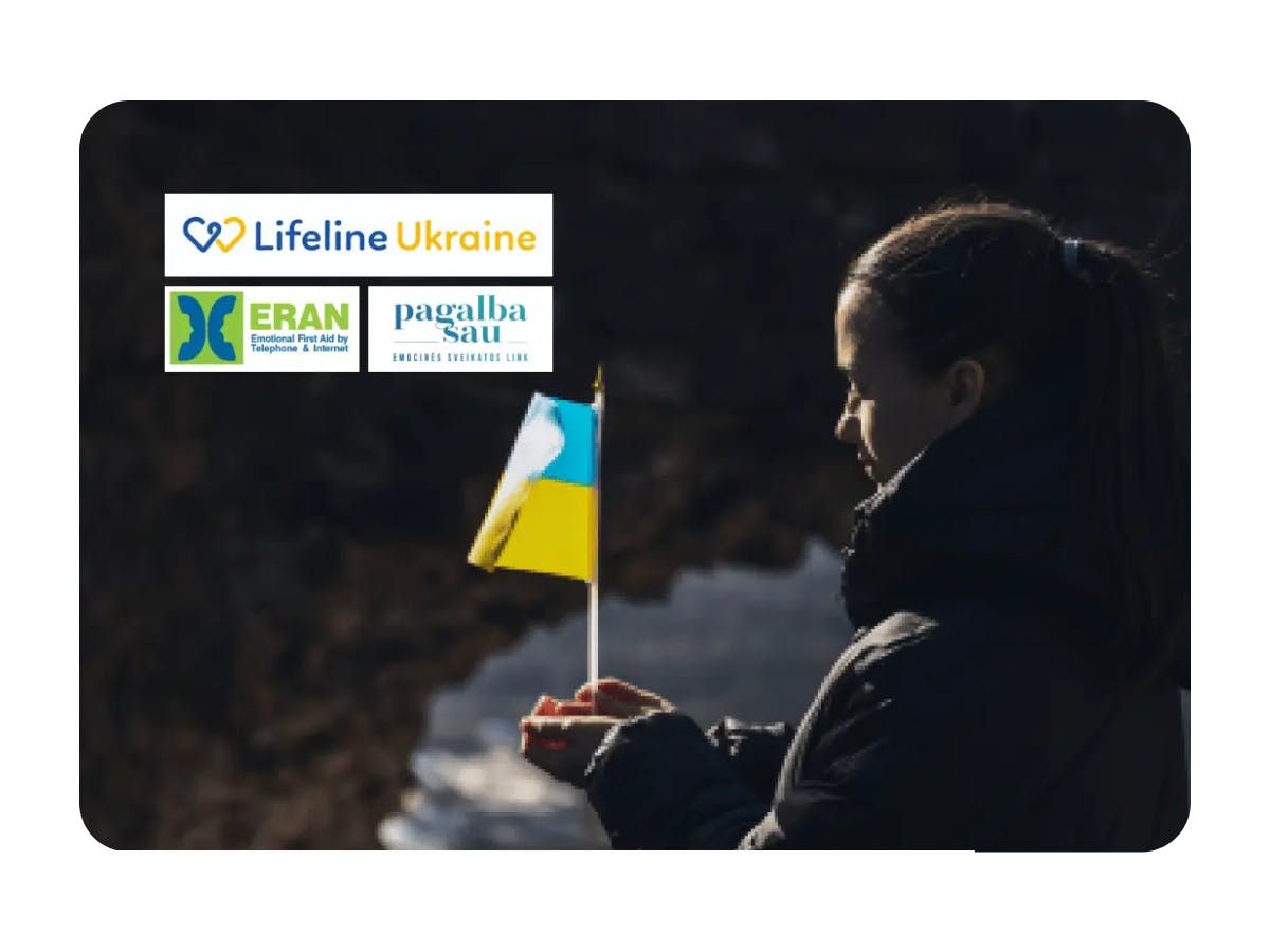 The image shows a girl holding the flag of Ukraine and standing by the lake