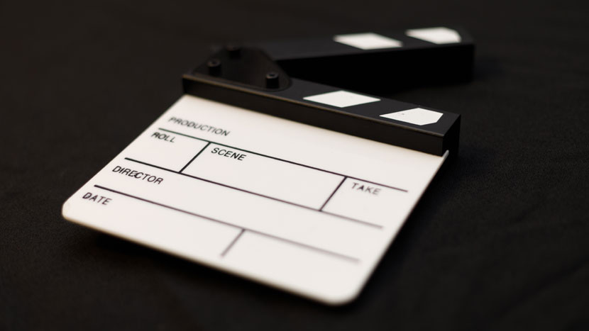 Image shows a film clapperboard in Black and White