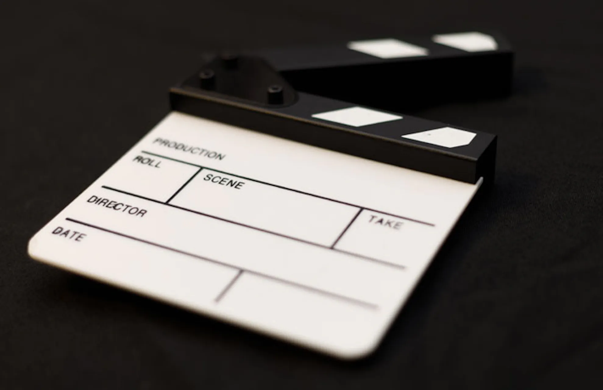 Image shows a film clapperboard in Black and White