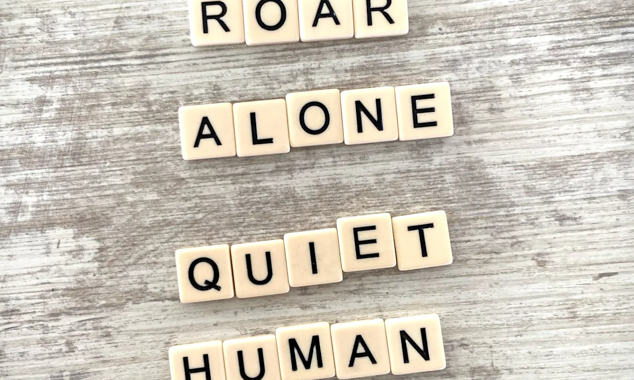 Scrabble letters reading Roar Alone Quiet Human