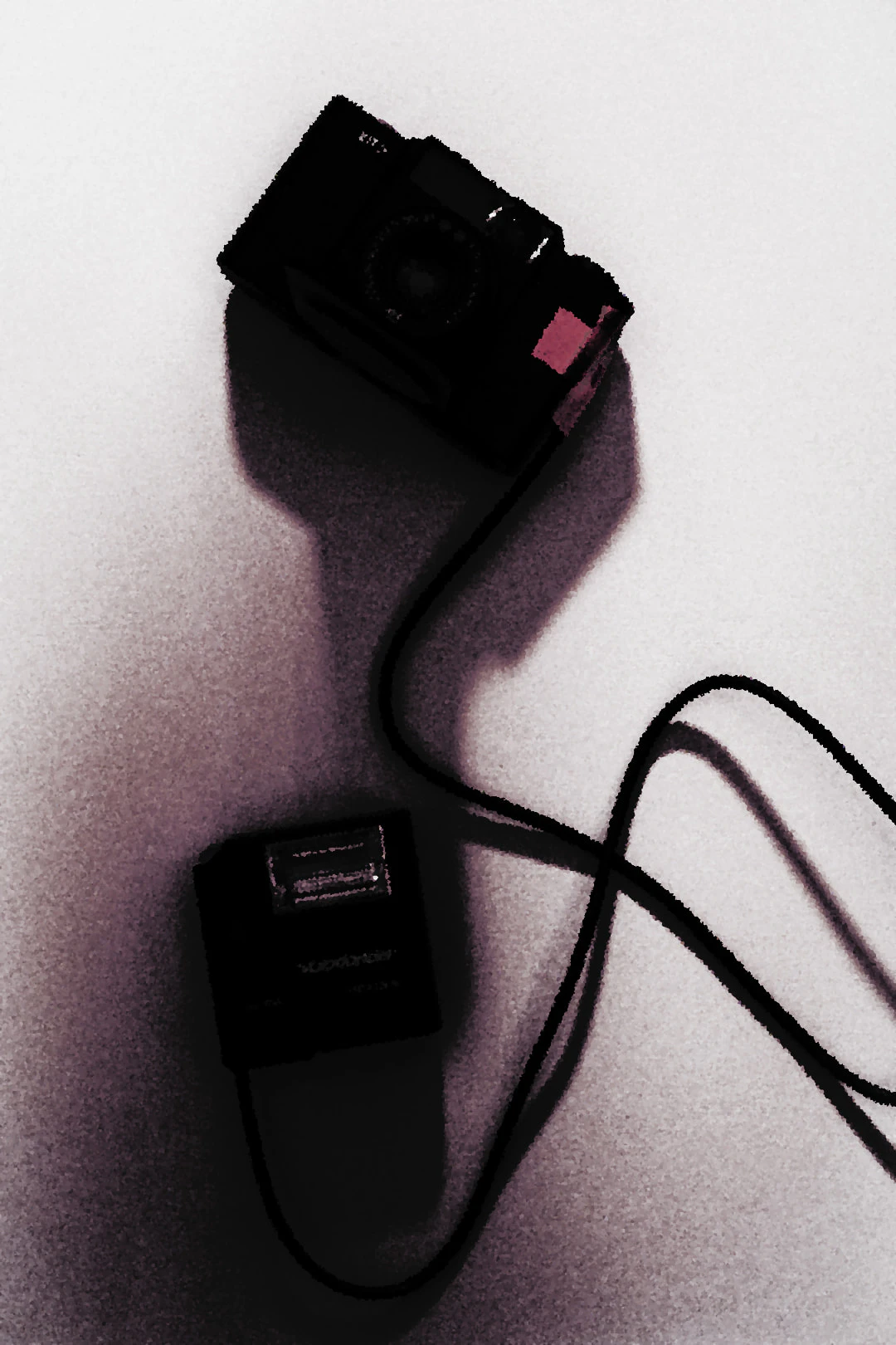 Voigtlander Vito film camera with red tape attached, connected by a cable to a compact Voigtlander flash unit on a light background.