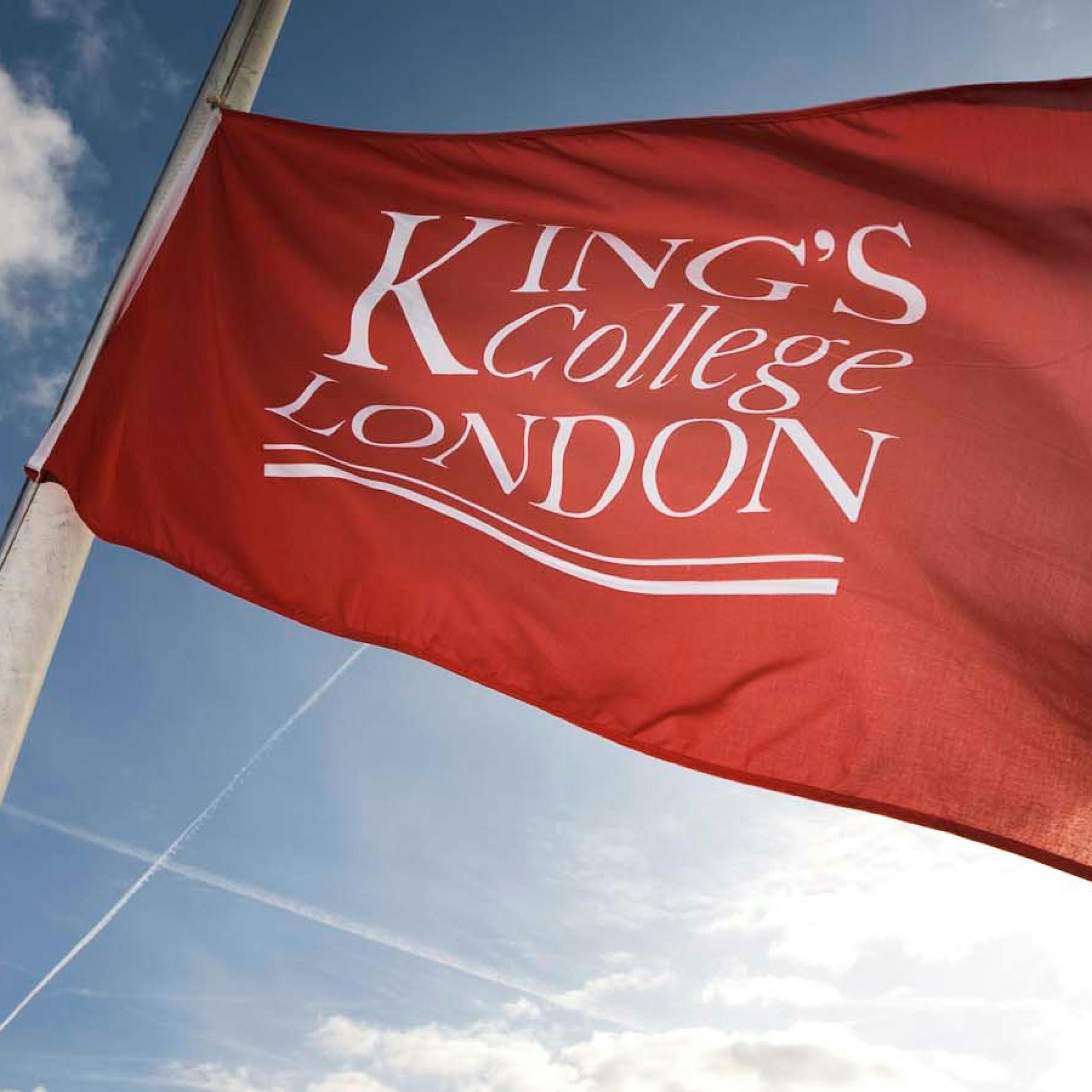 King's College London logo on a flag with a blue sky backdrop