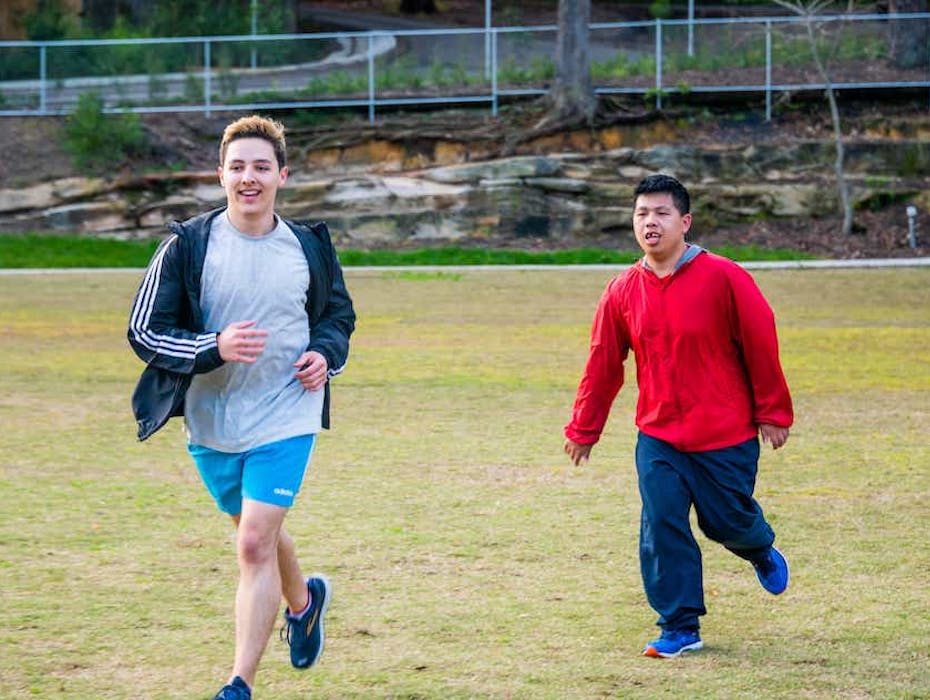 Two men running through a park