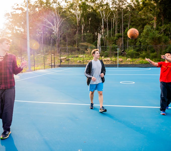 3 men playing basketball on a blue court