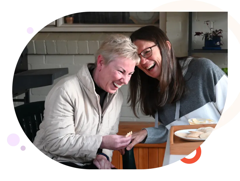 Two women laughing while having tea