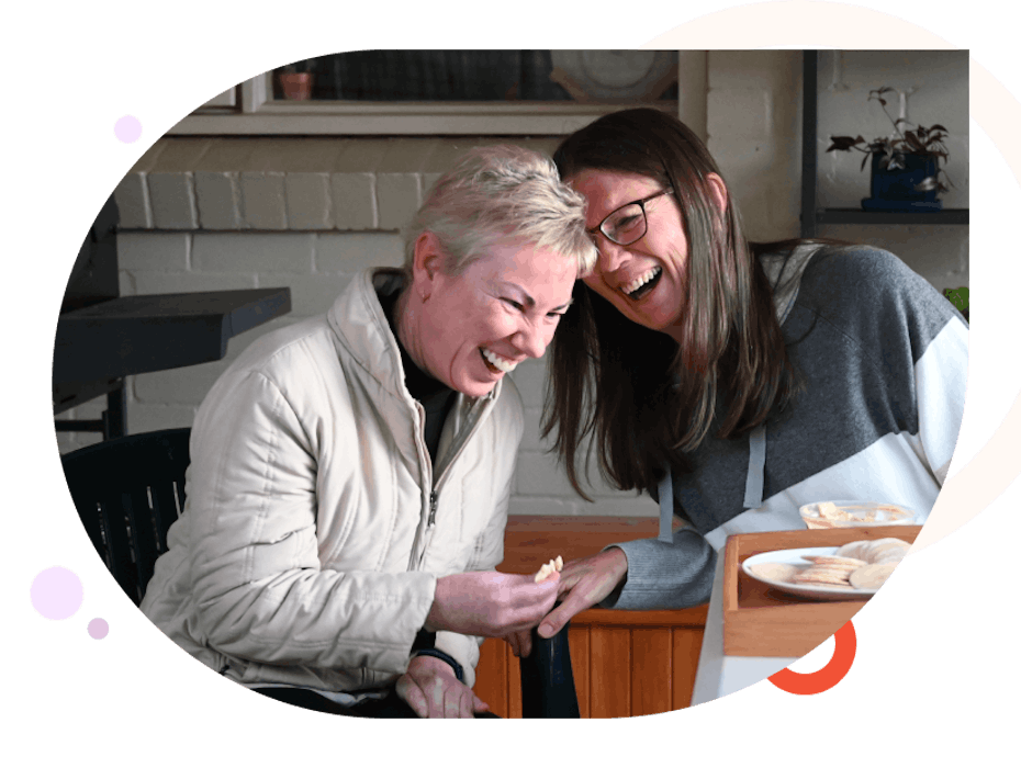 Two women laughing while having tea