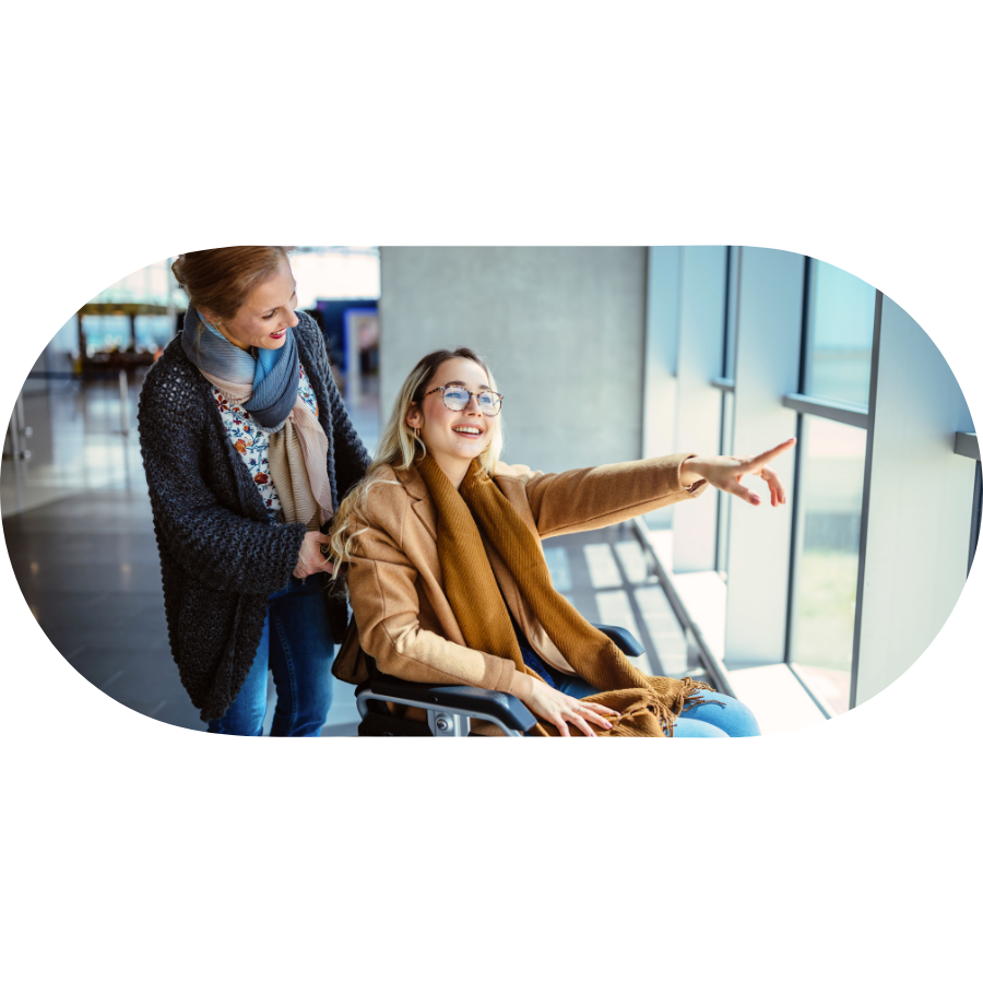 Support worker assisting a member in a wheelchair pointing out a window