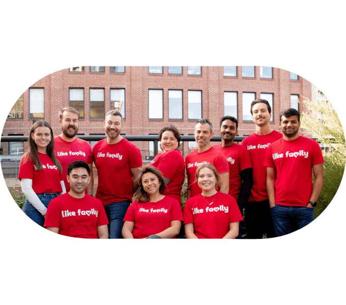Several Like Family workers in red shirts smiling at the camera