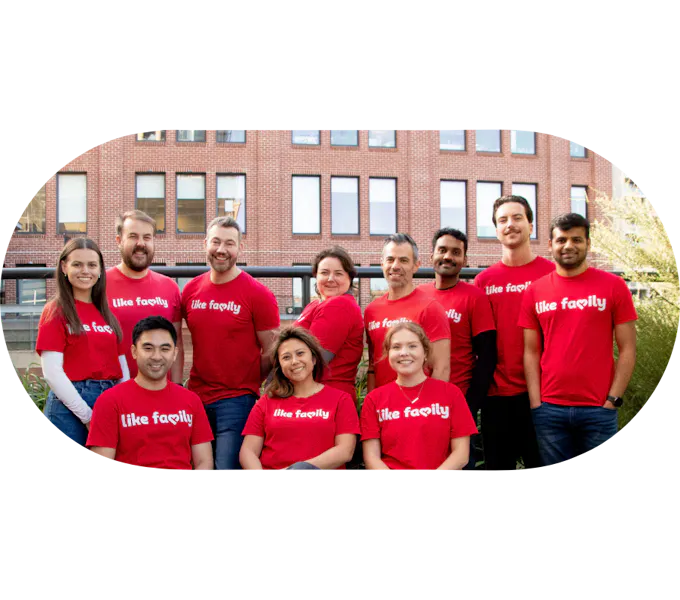 Several Like Family workers in red shirts smiling at the camera