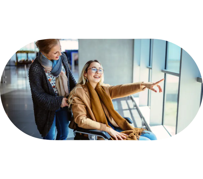 Support worker assisting a member in a wheelchair pointing out a window