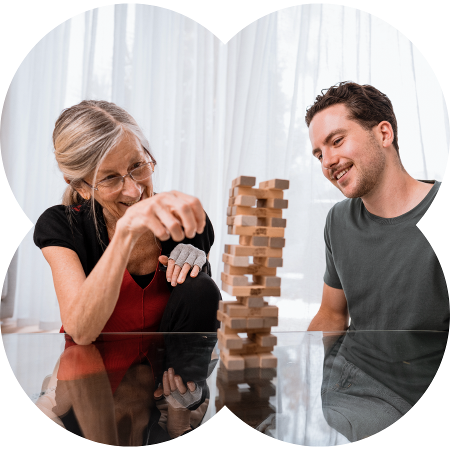 Support worker and a NDIS participant playing jenga and smiling