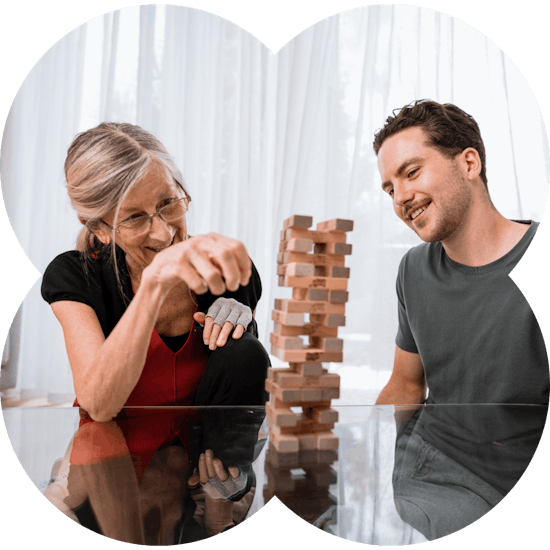 Support worker and a NDIS participant playing jenga and smiling