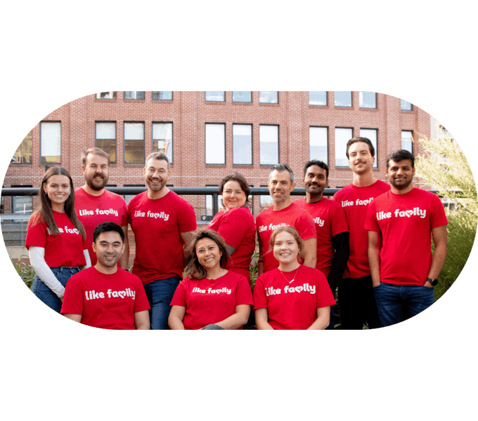 Several Like Family workers in red shirts smiling at the camera