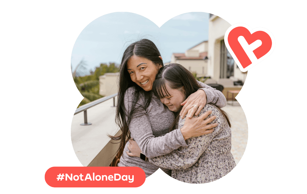 Two females in a warm friendly embrace, with the hashtag #NotAloneDay
