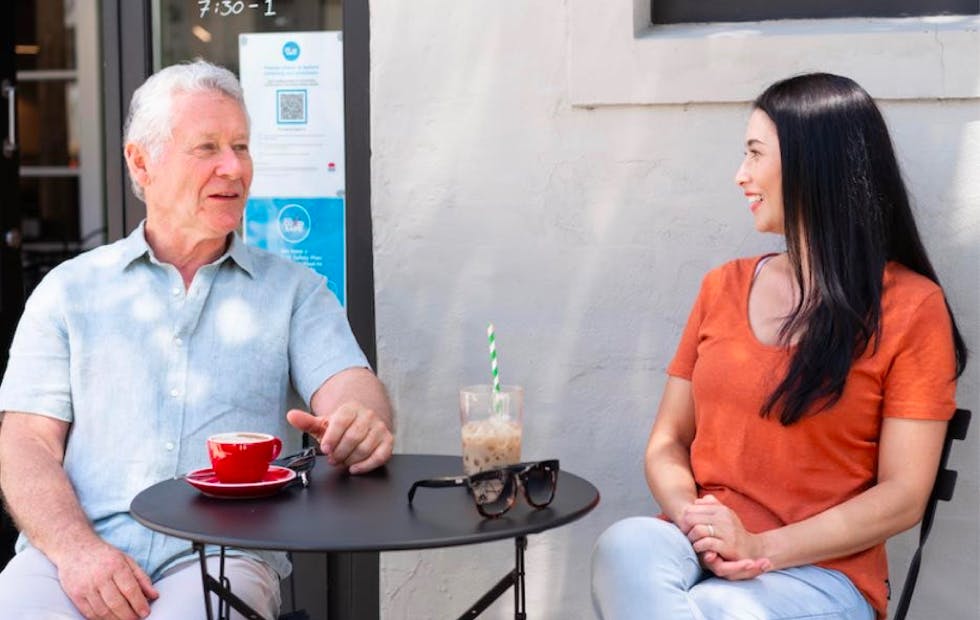 Carer and elderly member having a coffee