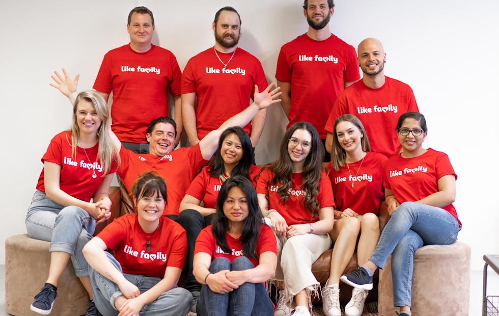 A group of people in Like Family tee shirts