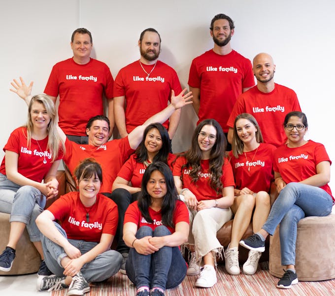 A group of people in Like Family tee shirts