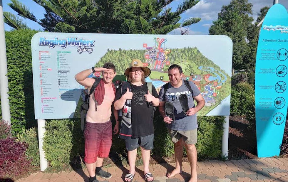 A Like Family Social Carer and 2 Members standing in front of a Raging Waters map