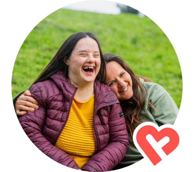 A Support Worker and Member sitting outside smiling