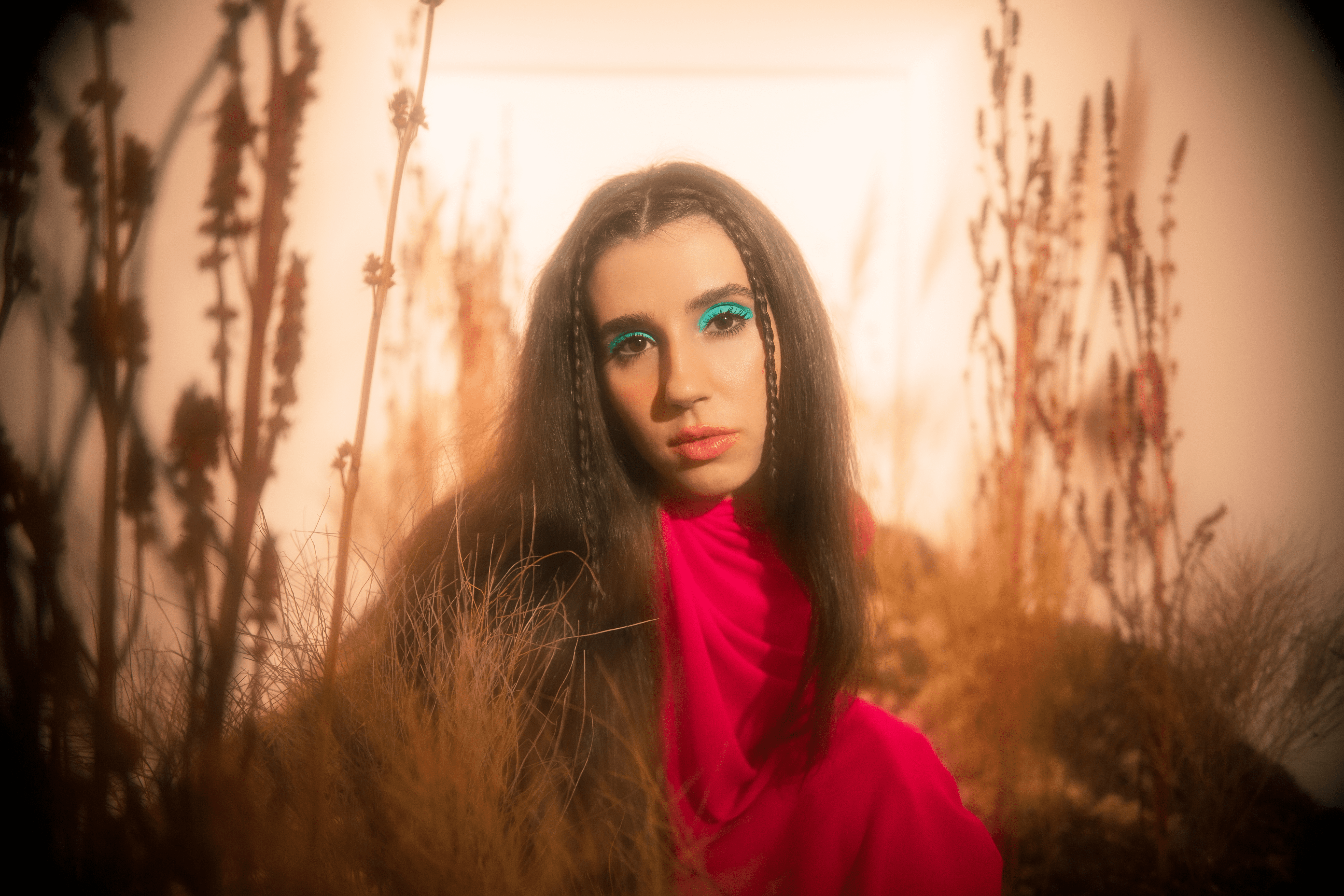 Nina Fernandes está de frente, com o cabelo liso, roupa rosa e sombra verde água