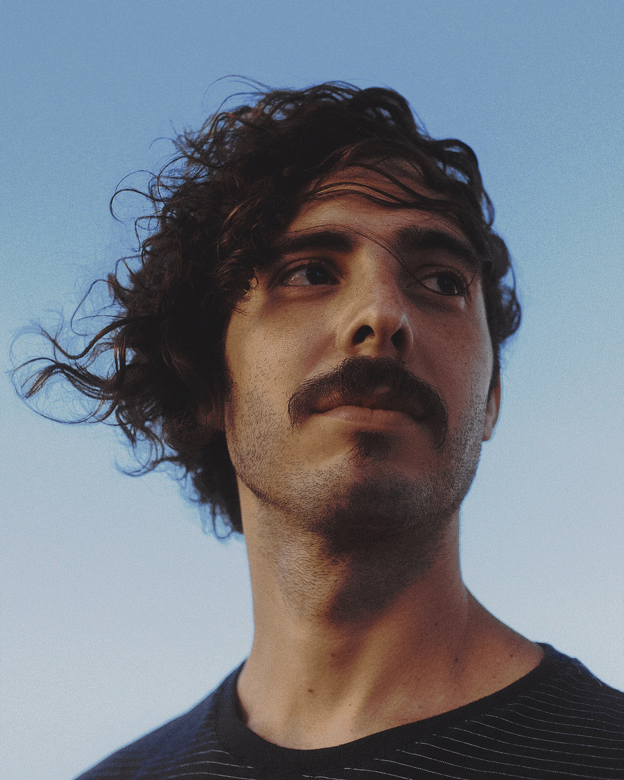 Rafael Martins posando para a foto a frente de um céu azul claro. Foto por Dário Matos