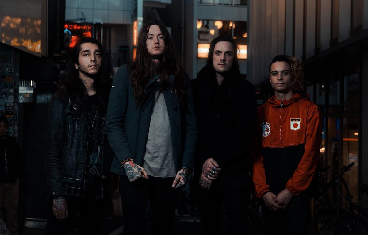 Bad Omens, formada por Noah Sebastian (voz), Nicholas Ruffilo (baixo), Joakim “Jolly” Karlsson (guitarra) e Nick Folio (bateria), posa para a câmera, todos estão sérios. 