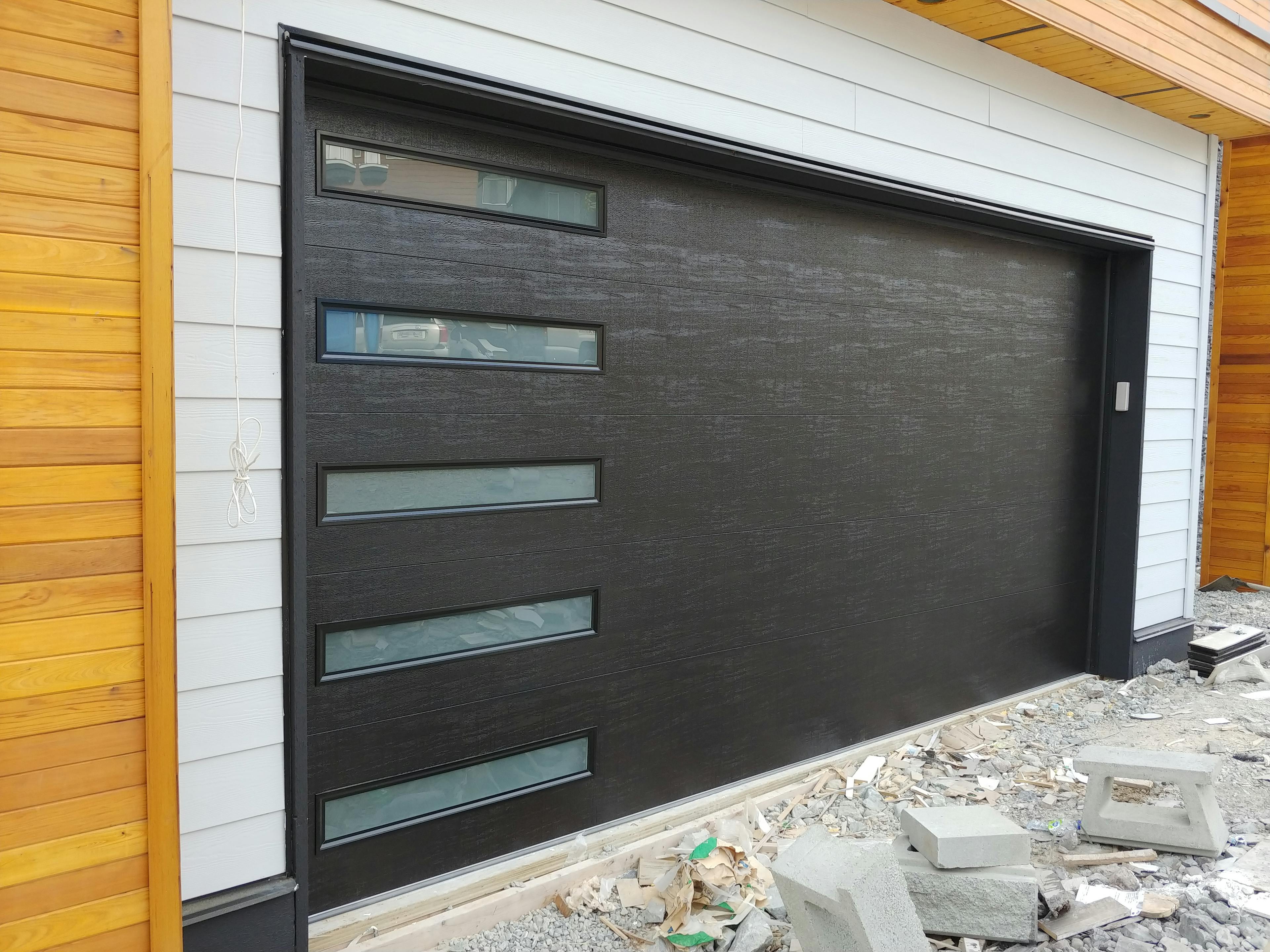 a 16'x8' Amarr Heritage Flush Panel in Black with Vertically Stacked and Frosted Glass windows
