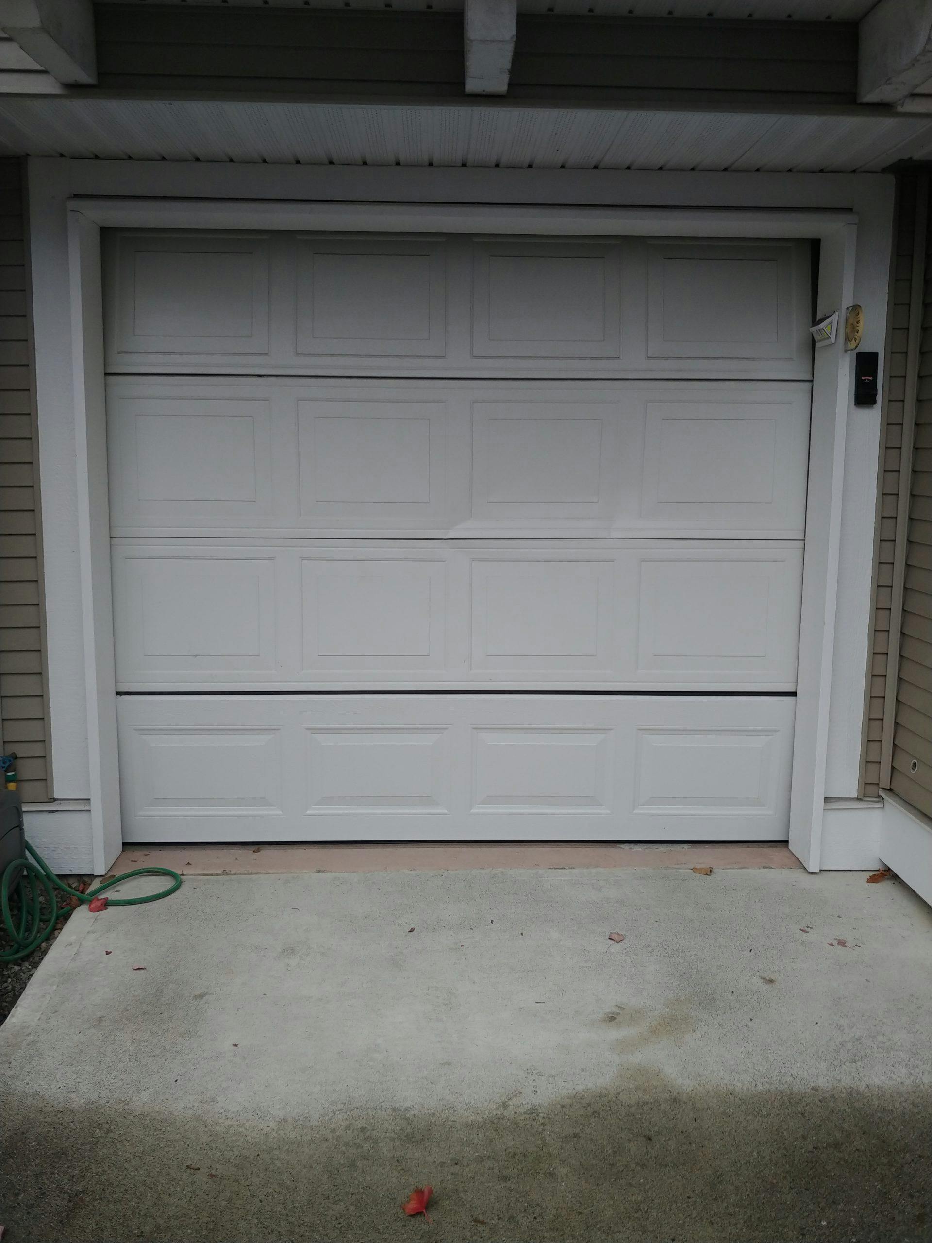 A broken garage door in need of replacement