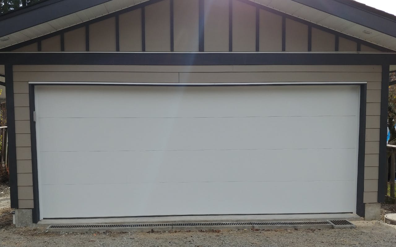 a New 17 x 7 Fully Insulated Northwest Door Therma Tech Contemorary Flush Panel. R-9.0 in White Colour