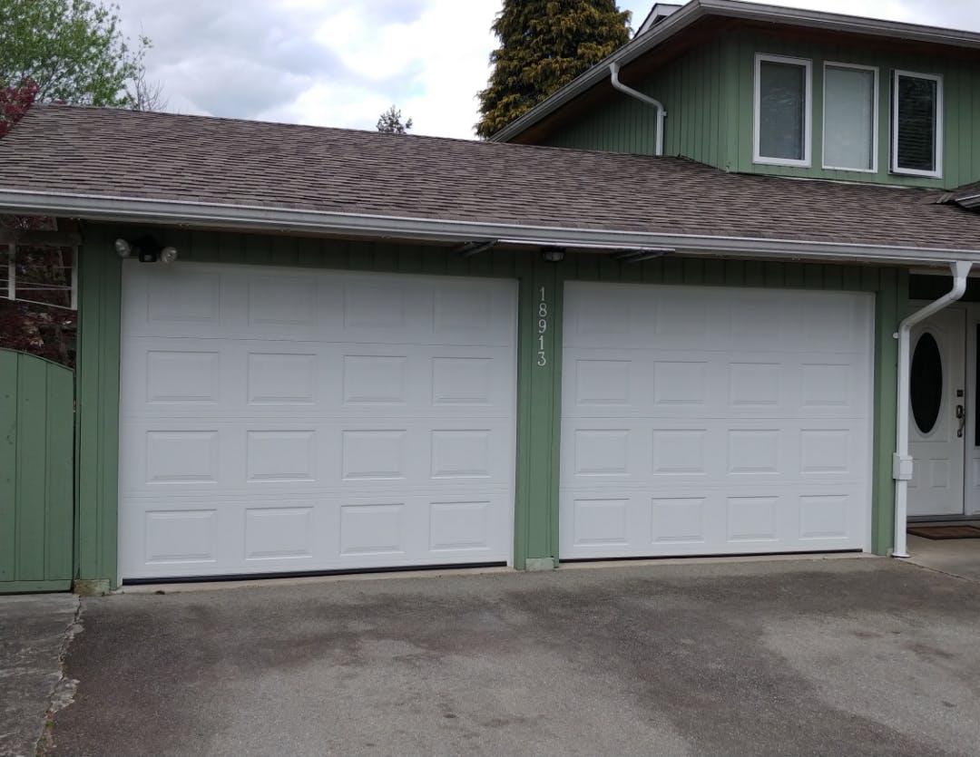 two new white garage doors installed by Lions Gate Garage Doors