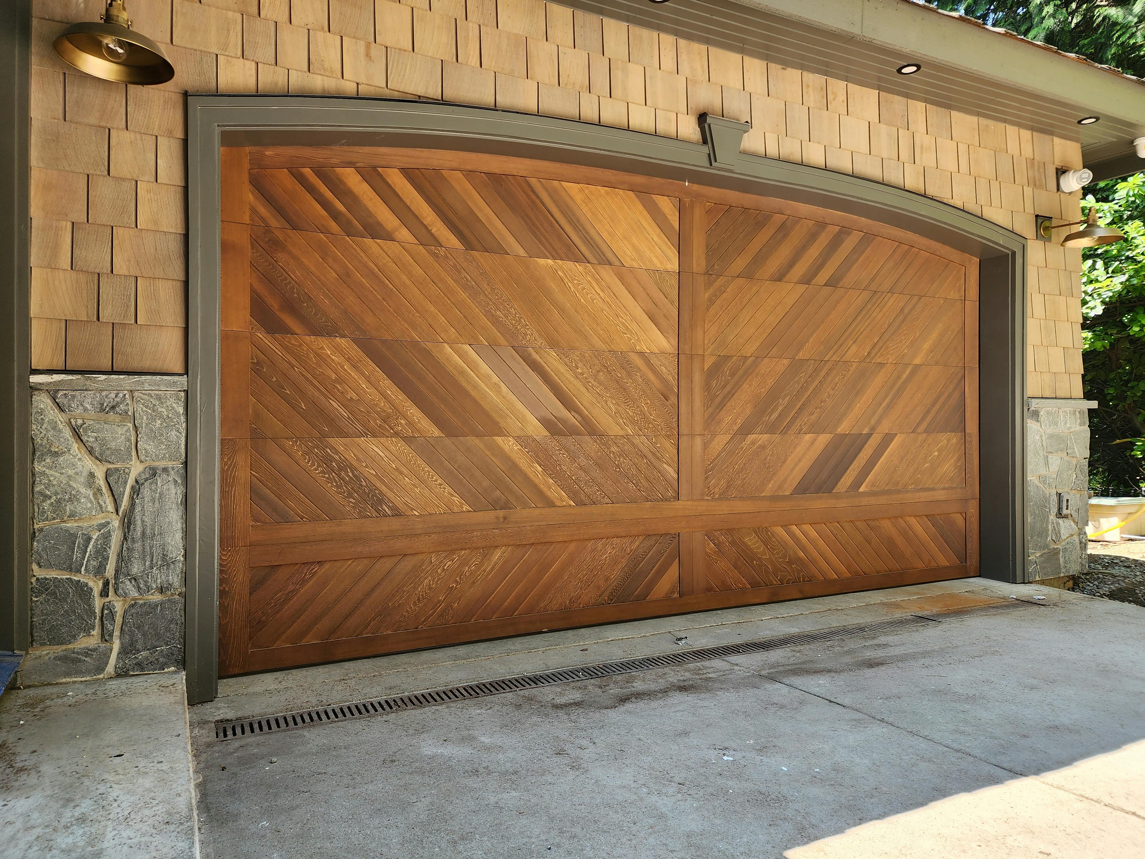 a 16'x8' Amarr Heritage steel door. It's a 25-gauge fully insulated door, 2" thick, with 3" commercial-grade hardware. We added a 2" thick custom Cedar Wood Overlay on the door's face to enhance its durability and design