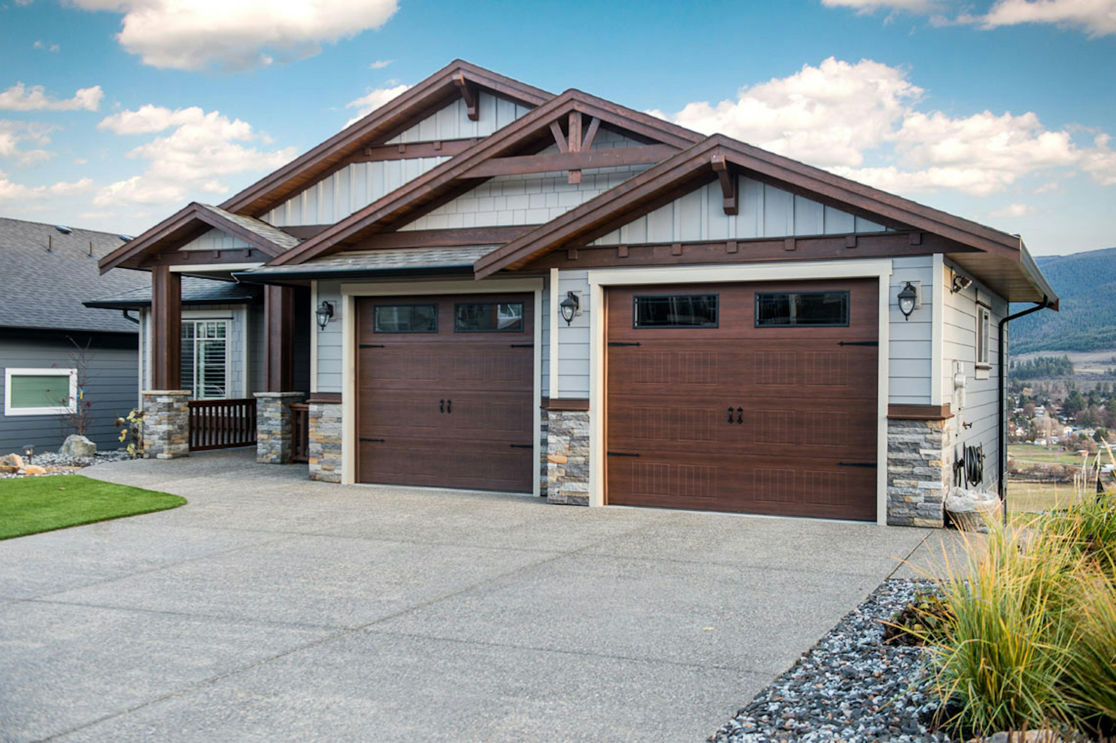 Two cherry stained woodgrain Carriage-Craft garage doors