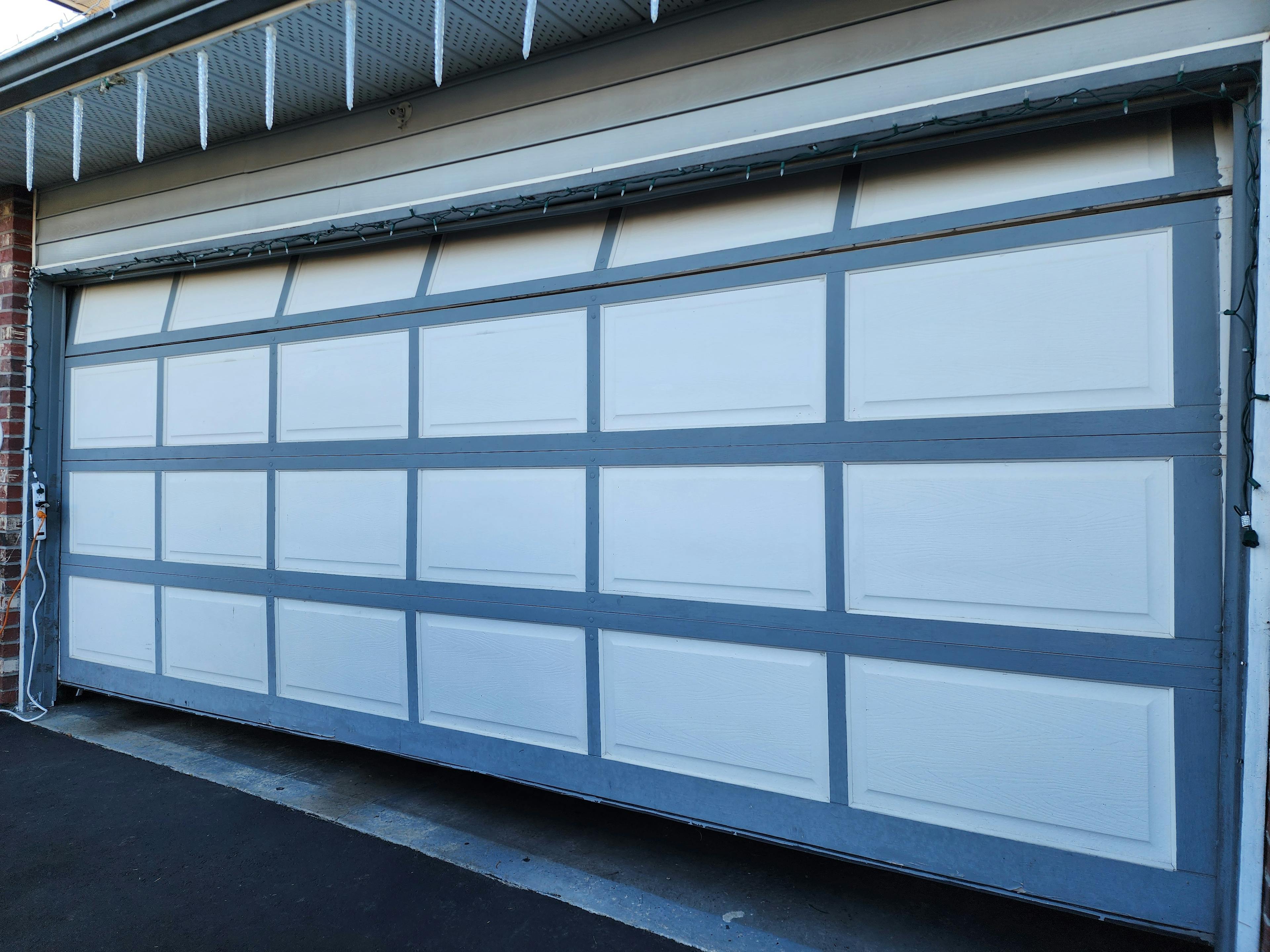 Crooked garage door needing repair in Langley