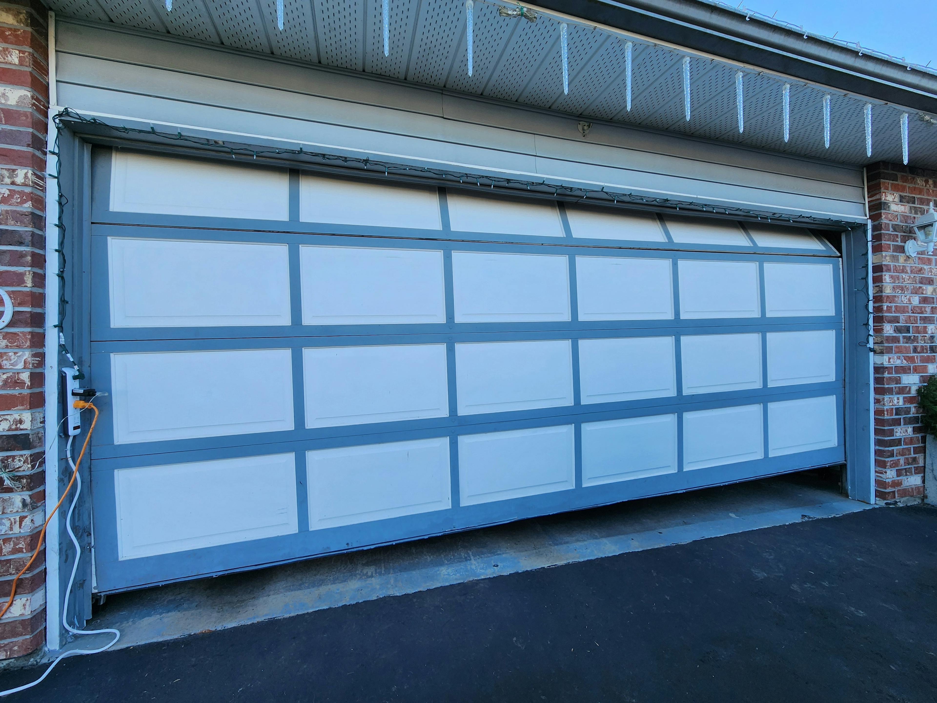 A crooked garage door was bumped by a car.