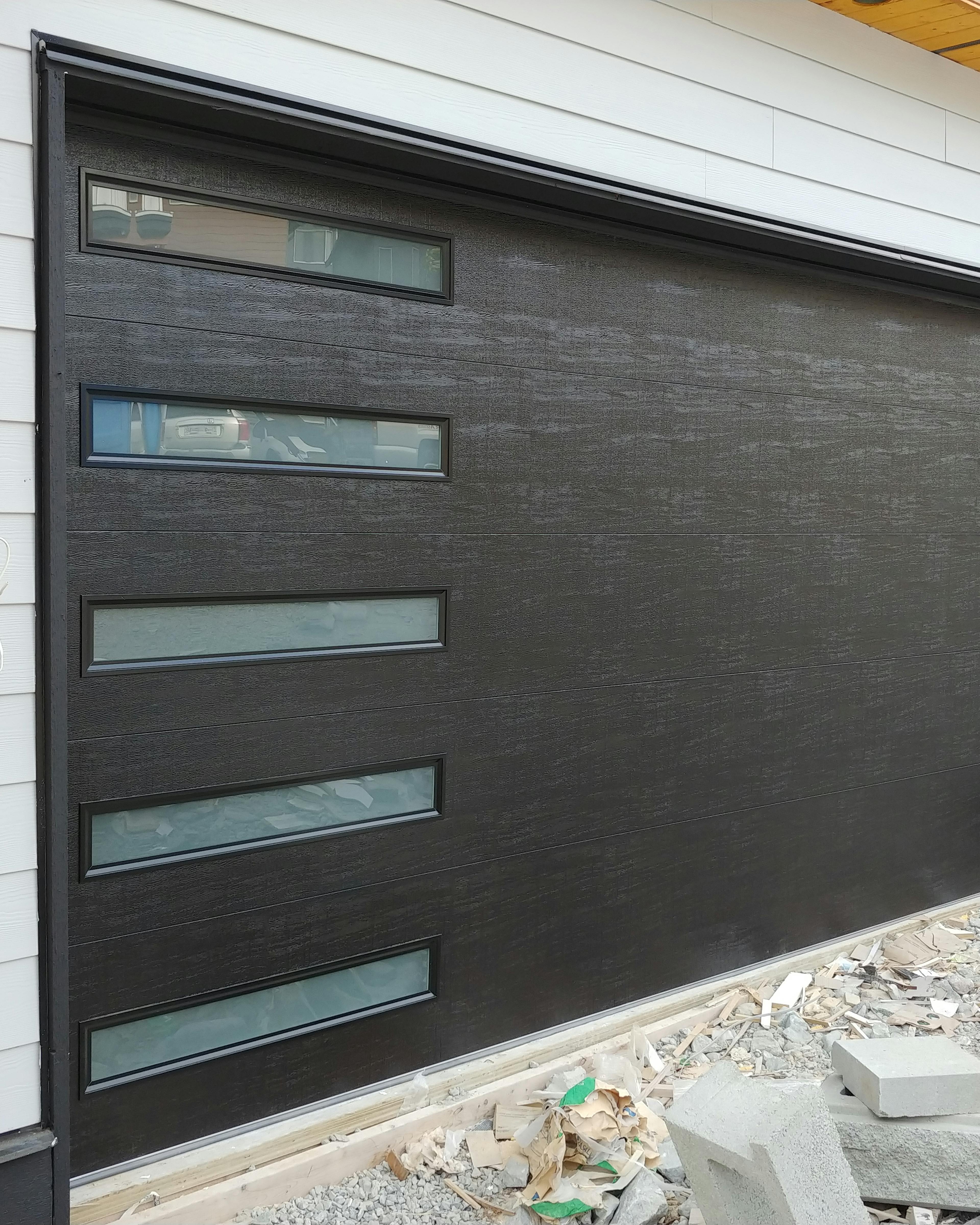 Dark garage door with slim glass panels on the left