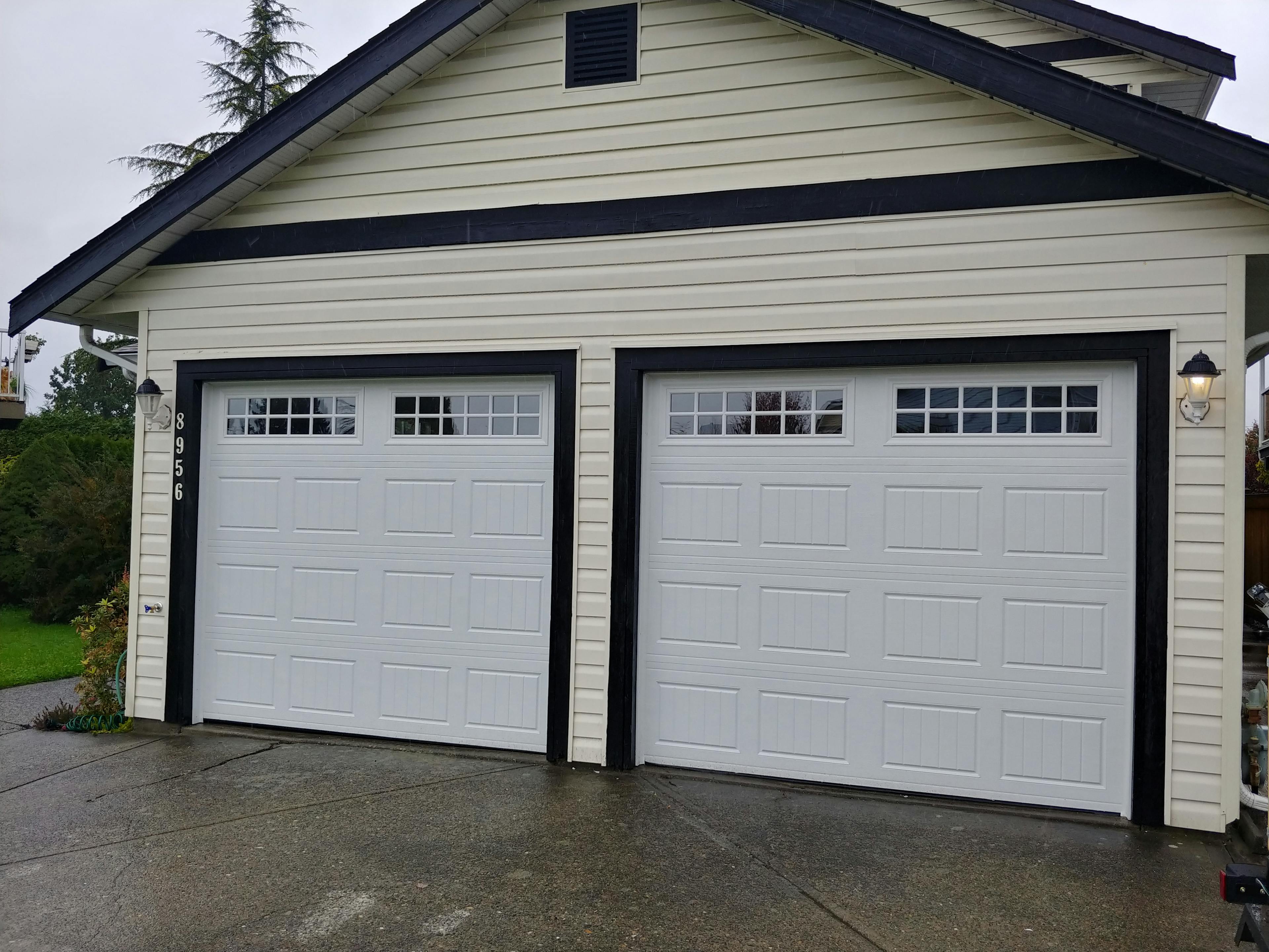 White paneled garage doors with small glass panels at the top