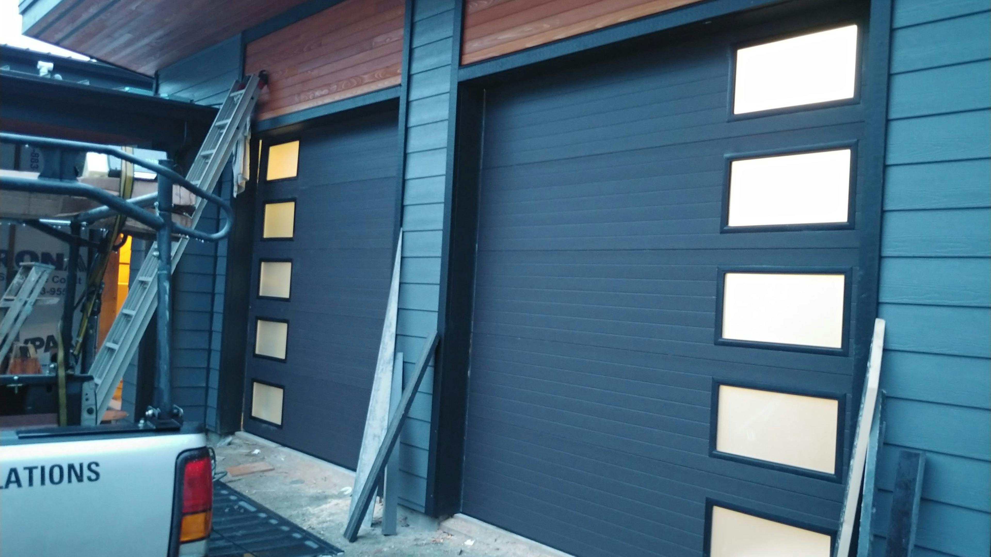 Matching dark garage doors with glass panels on the sides