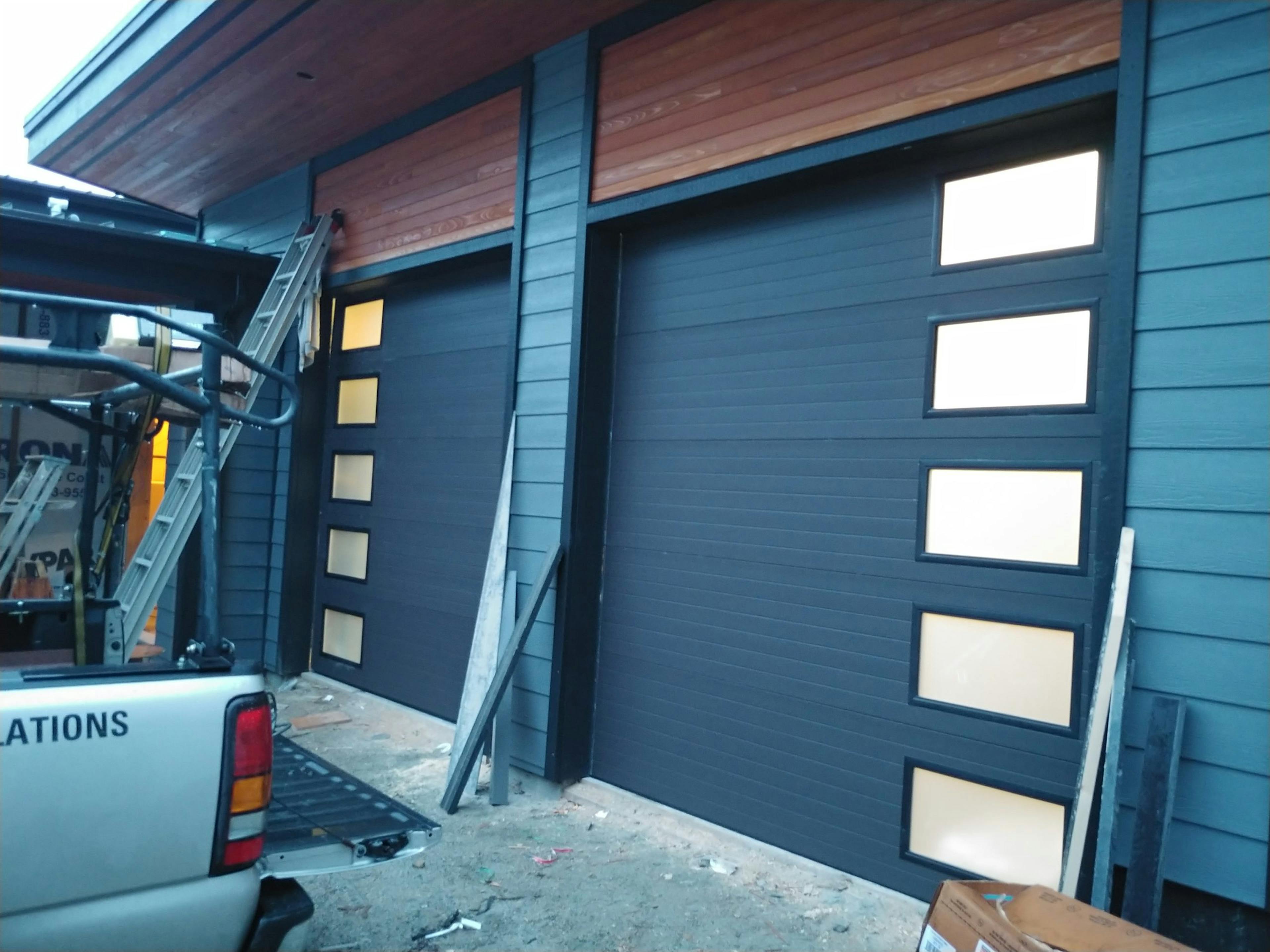 Matching dark garage doors with glass panels on the sides